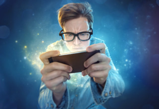 Guy with spectacles playing game on mobile