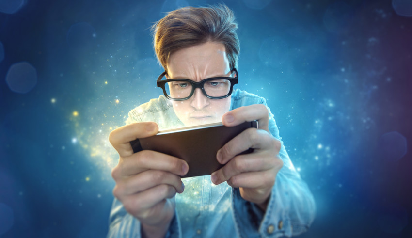 Guy with spectacles playing game on mobile