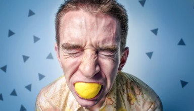 man Squeezing lemon in mouth