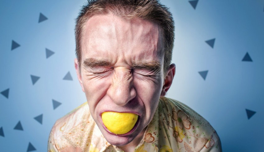 man Squeezing lemon in mouth