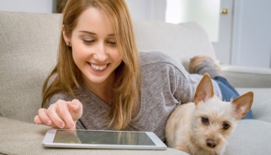 girl using tablet and sitting with dog