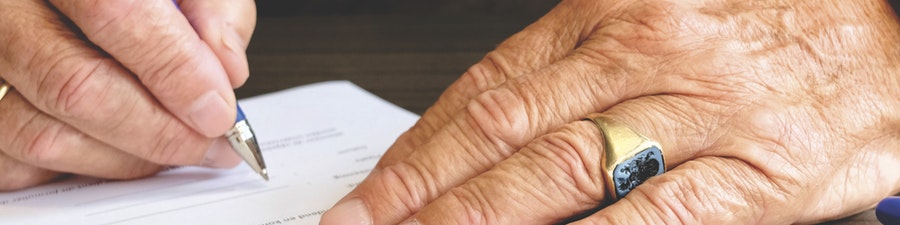 man signing document